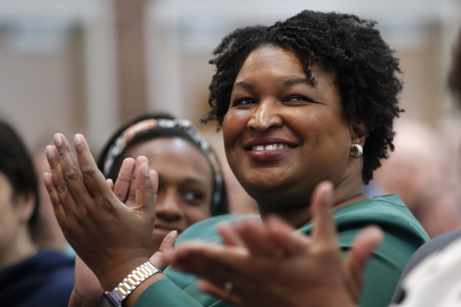 Stacey Abrams clapping in a crowd of people.