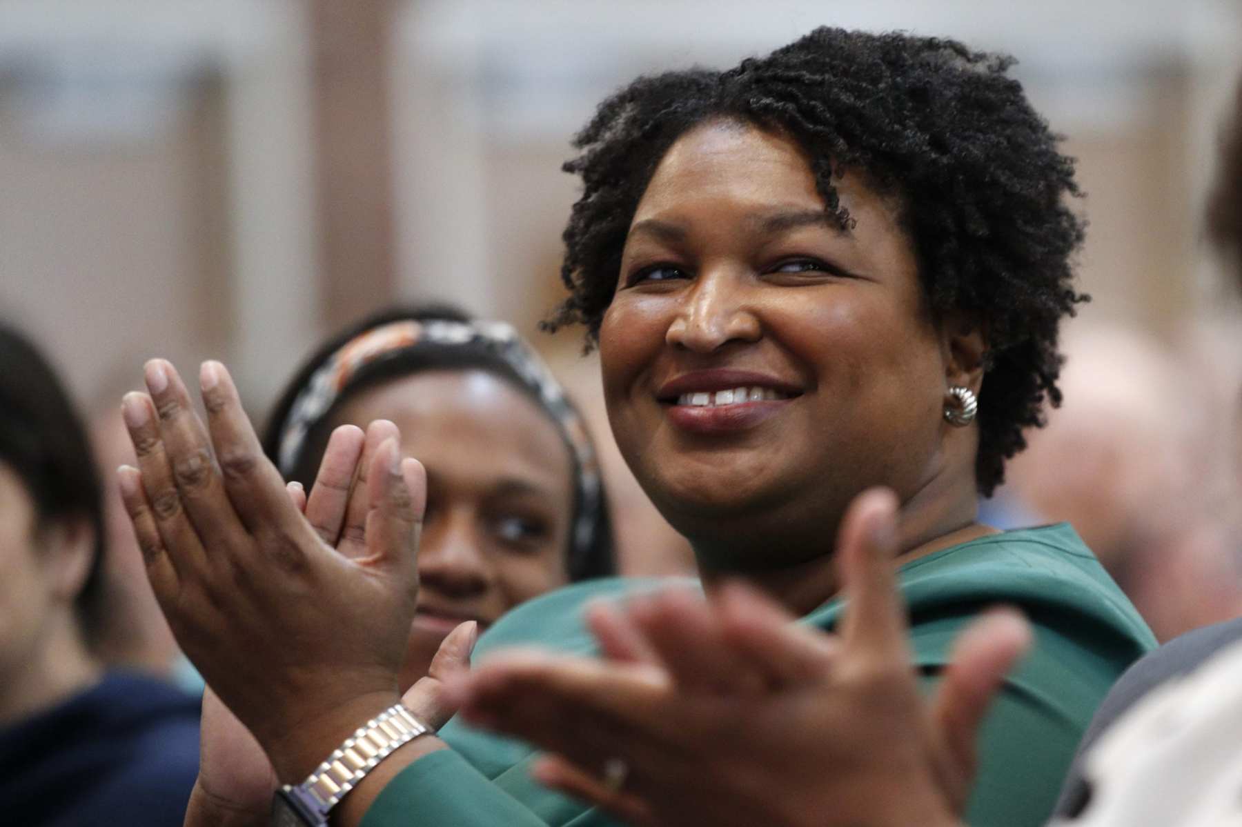 Stacey Abrams clapping in a crowd of people.