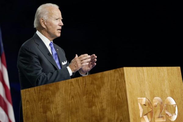 Joe Biden stands at a lecturn.