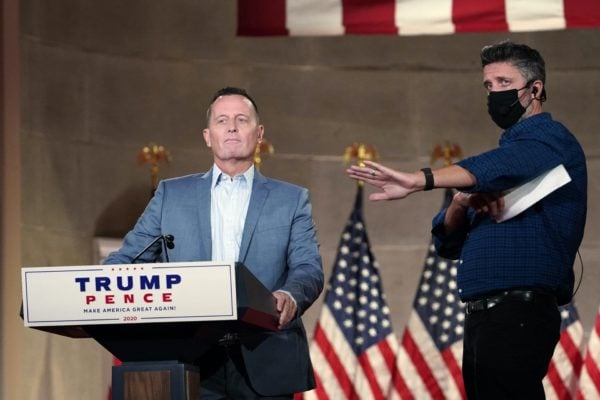 Richard Grenell stands at a Trump-Pence podium.