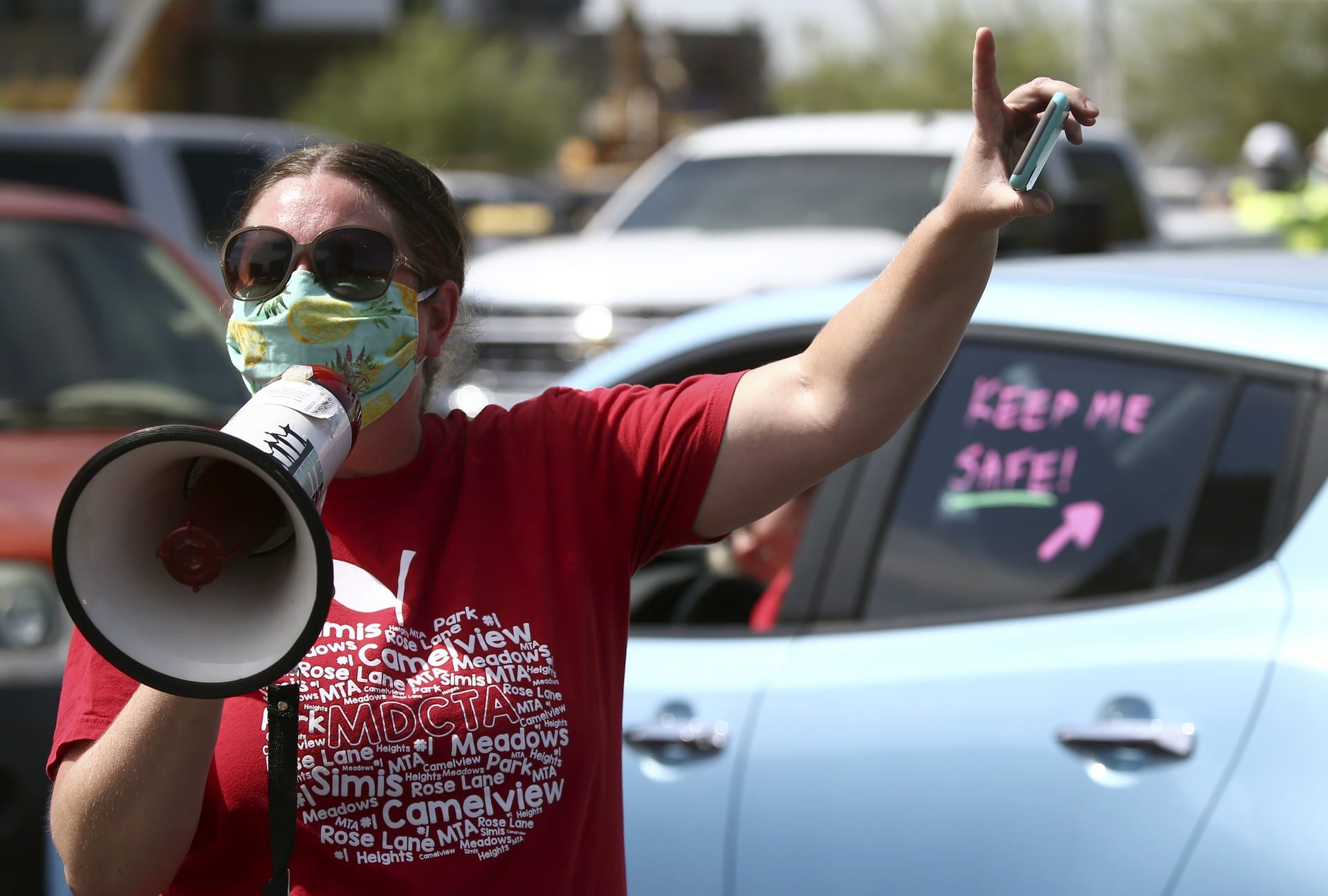 A woman holding a megaphone protests at a teacher strike in Arizona.