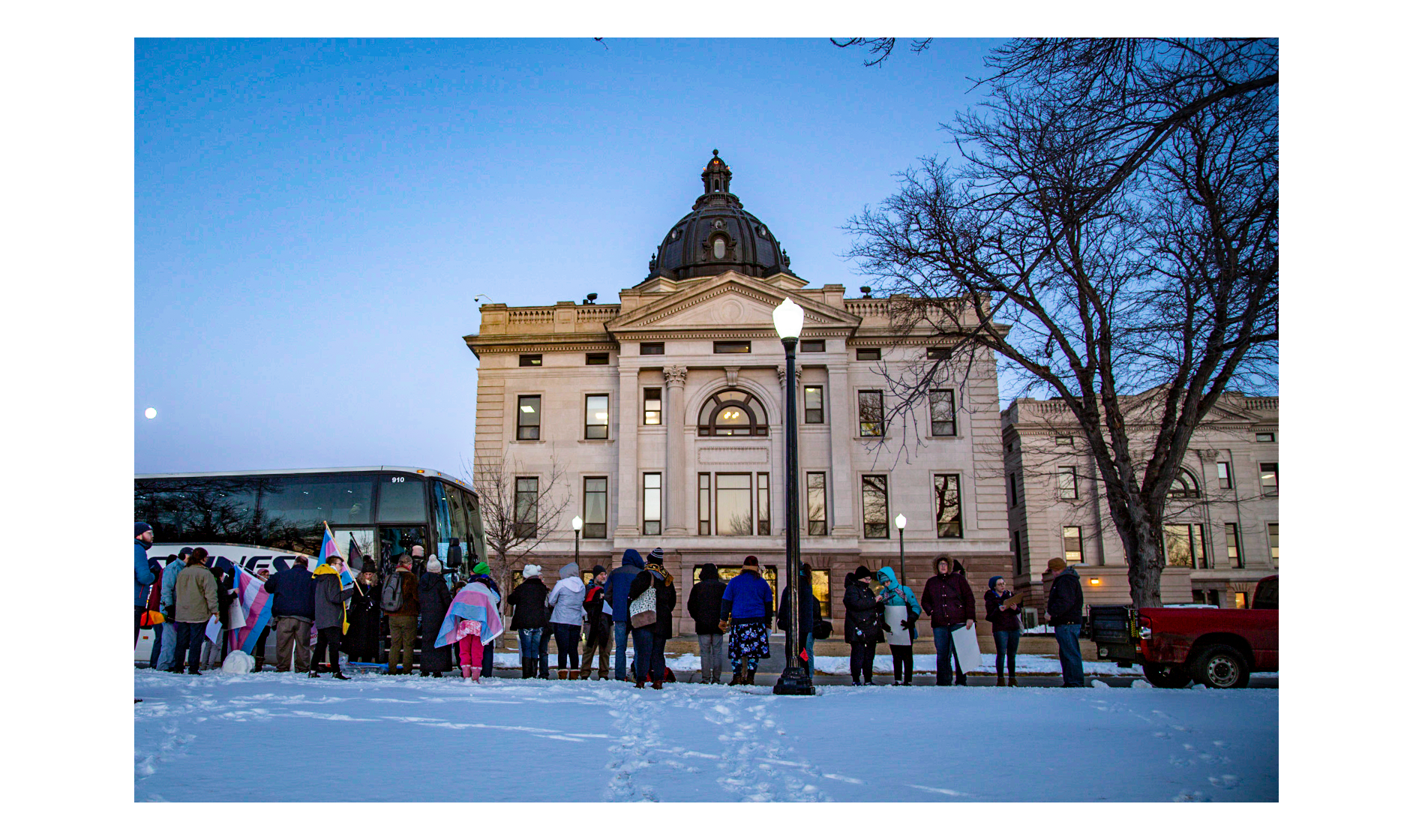 People disembark from a bus with snow on the ground.