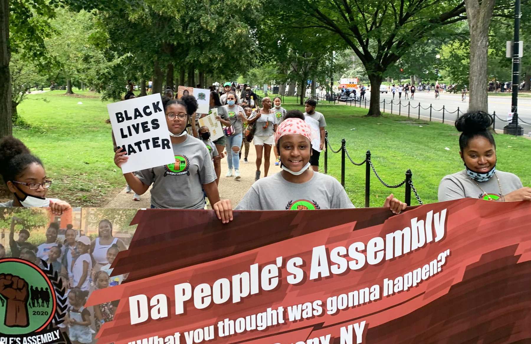A group of children and parents from the Bronx, holding a banner that reads Da People's Assemblage, attending the 2020 March on Washington to protest.