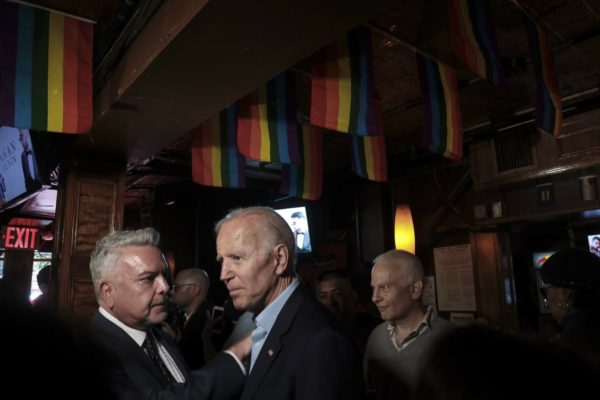 Joe Biden at the Stonewall Inn standing under LGBTQ flags.