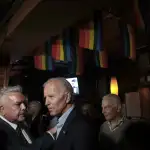 Joe Biden at the Stonewall Inn standing under LGBTQ flags.