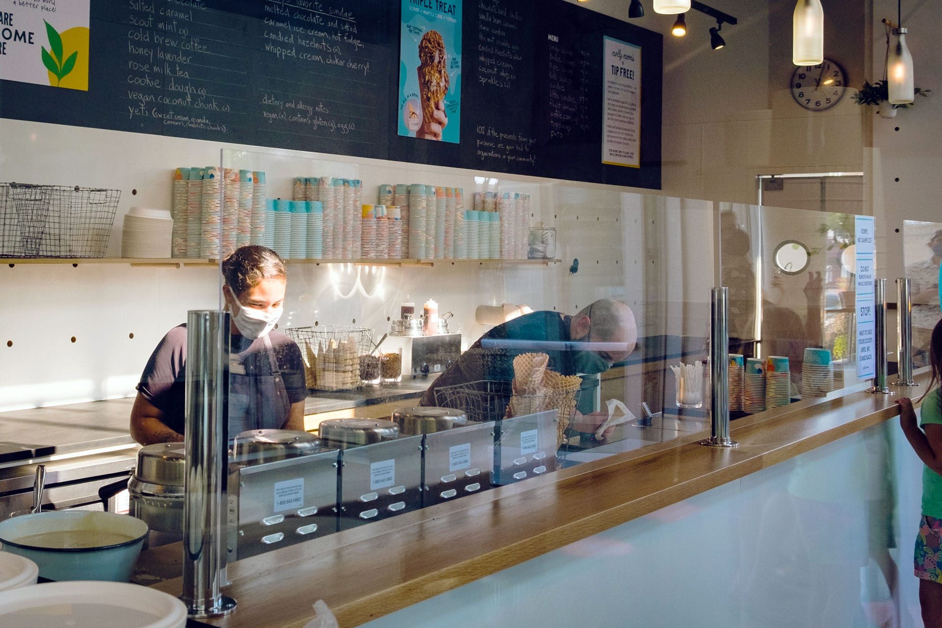 Two workers behind the counter at an ice cream shop.