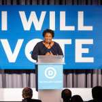 Stacey Abrams speaks at a podium.