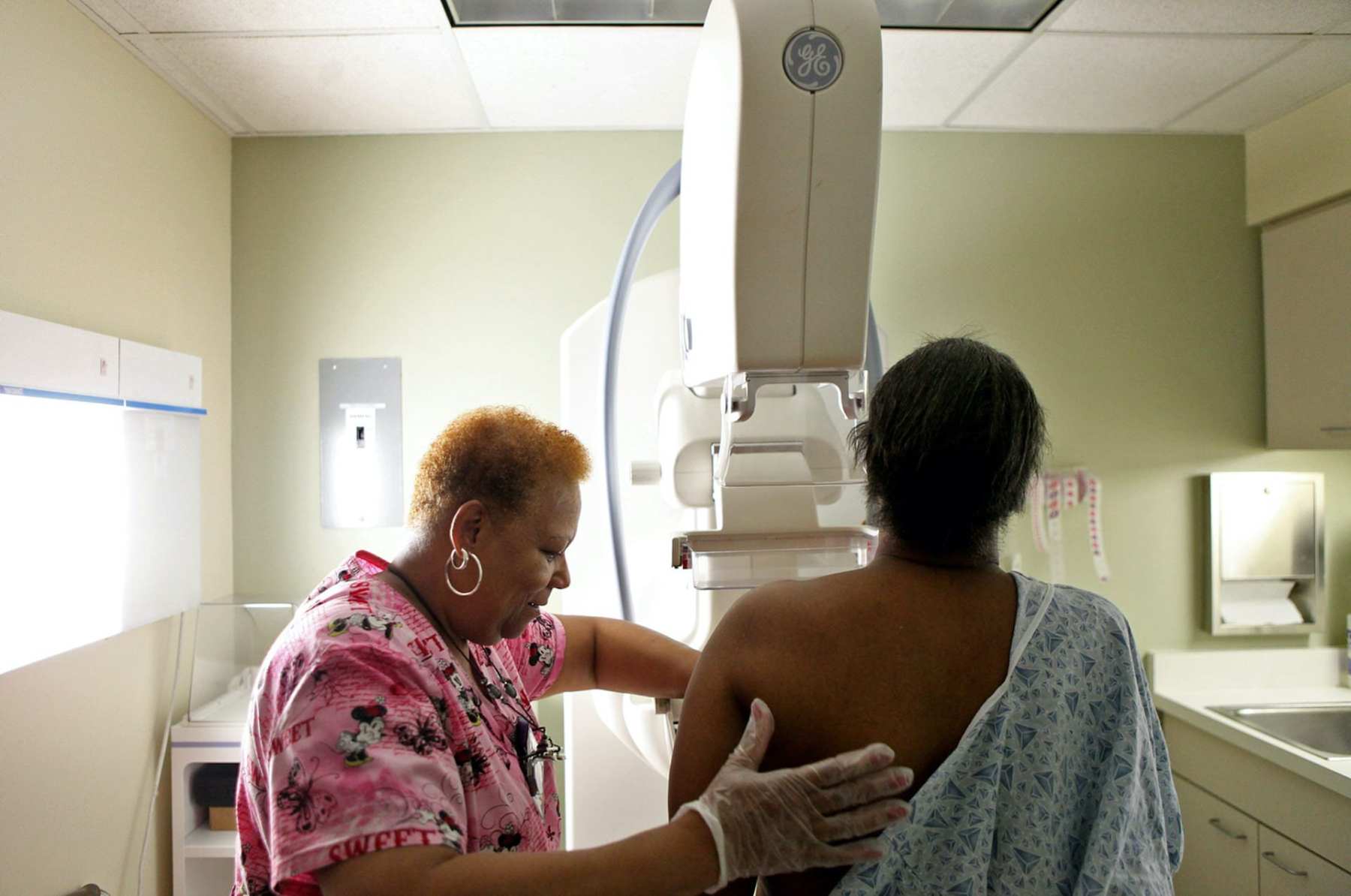 A woman administers a mammogram to another woman.