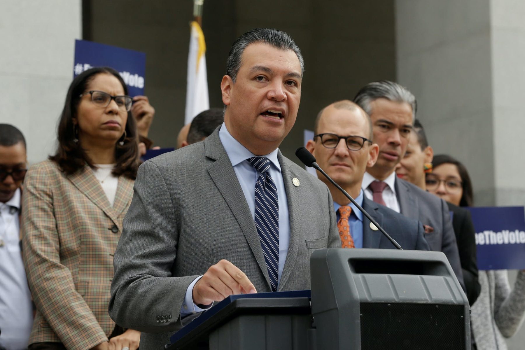 Alex Padilla stands at a podium and speaks into a microphone.