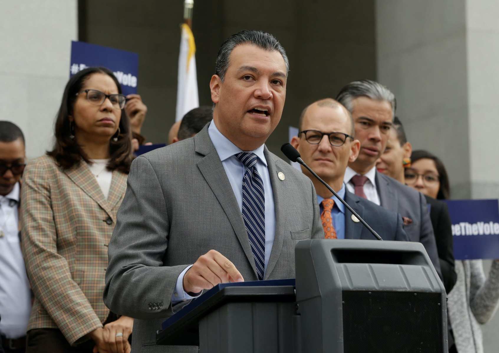 Alex Padilla stands at a podium and speaks into a microphone.