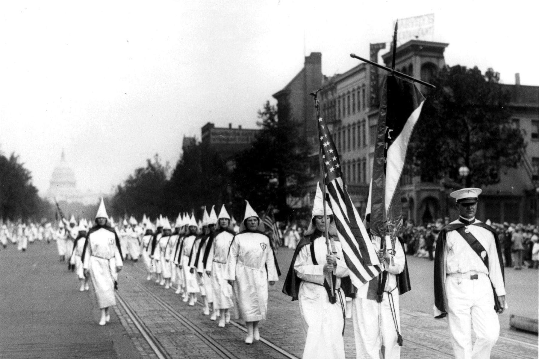 A line of women marching in a KKK parade.