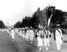 A line of women marching in a KKK parade.