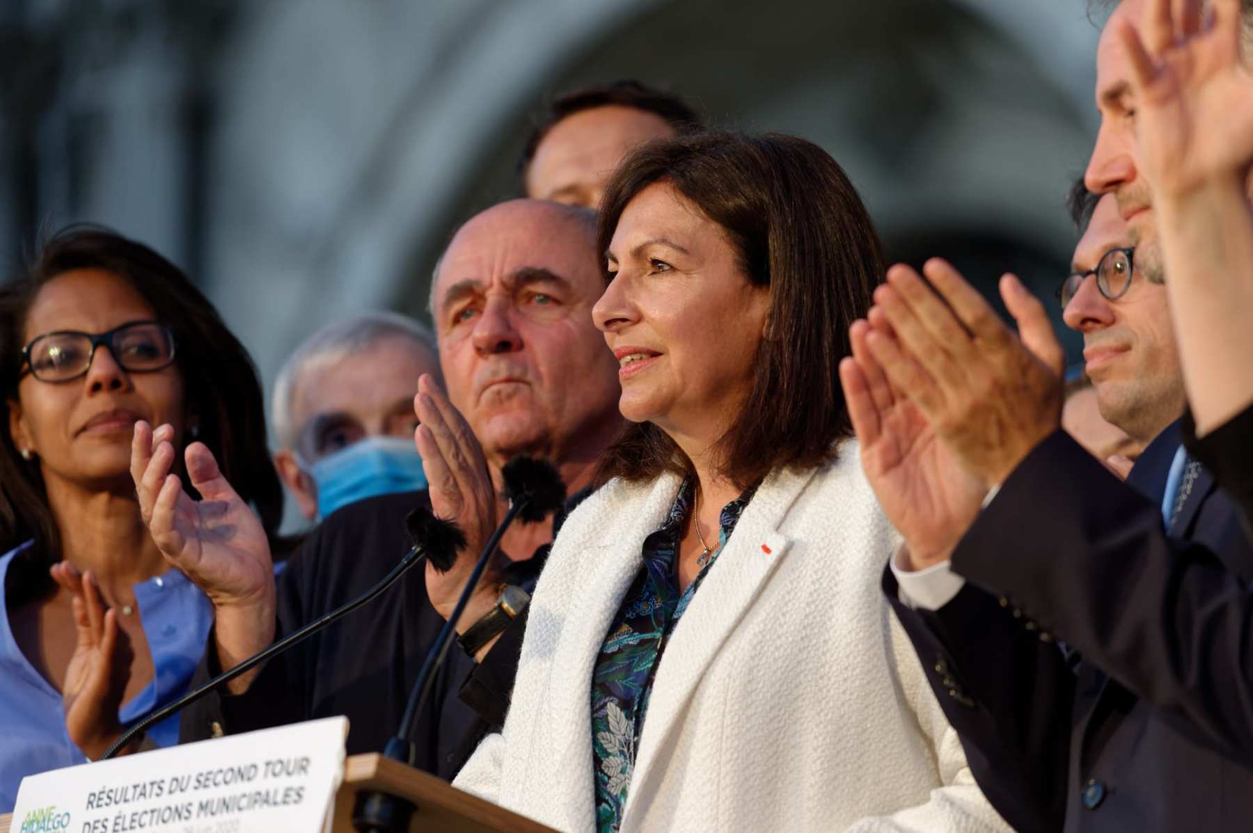Paris Mayor Anne Hidalgo stands at a podium.
