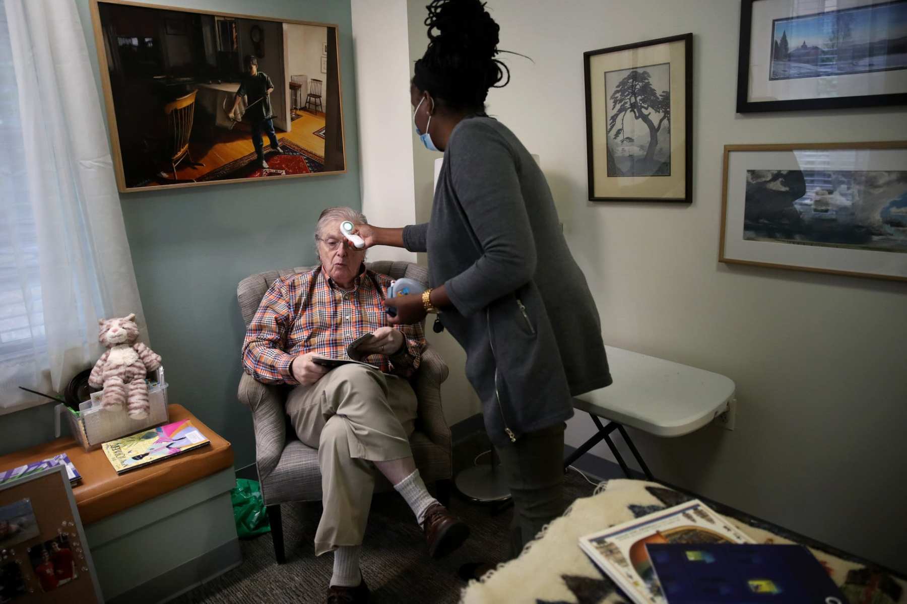 A resident of an assisted living facilty gets his temperature checked.