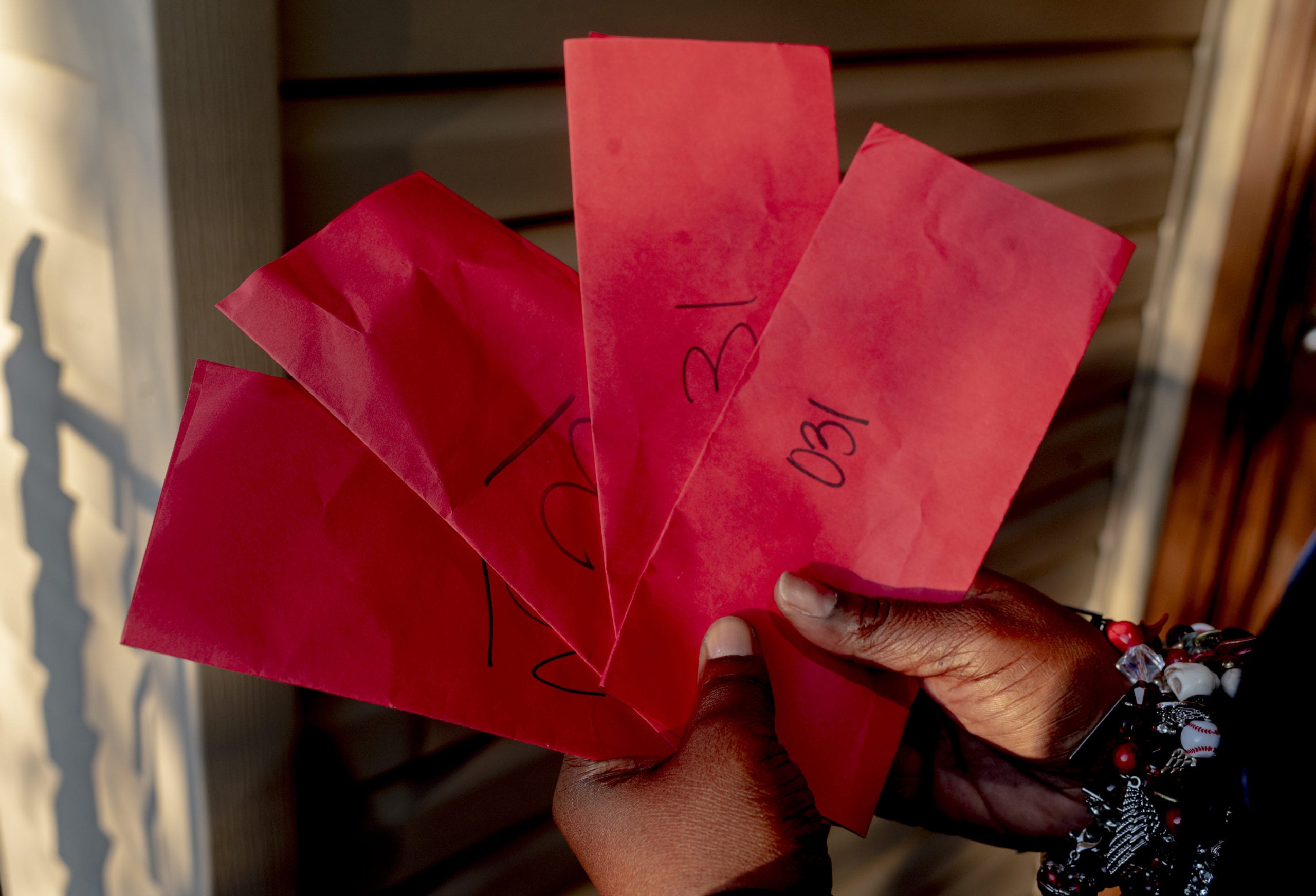 Shanta Scott holds some of the eviction notices, or red slips, she received after losing her job in March 2020.