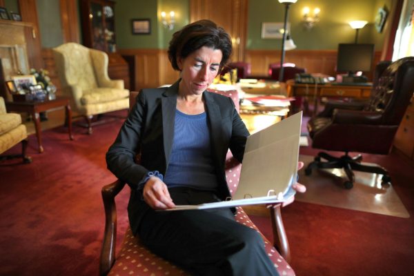 Gina Raimondo reads a document in her office.