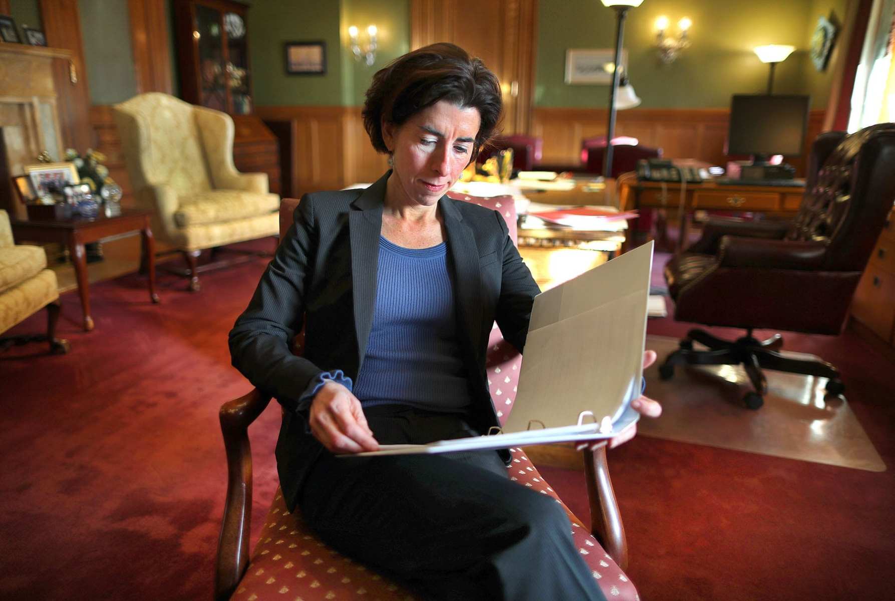 Gina Raimondo reads a document in her office.