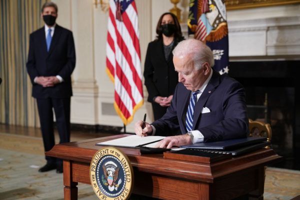 US Vice President Kamala Harris and Special Presidential Envoy for Climate John Kerry watch as US President Joe Biden signs executive orders.