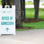 A sidewalk sign for the University of Miami Office of Admissions.