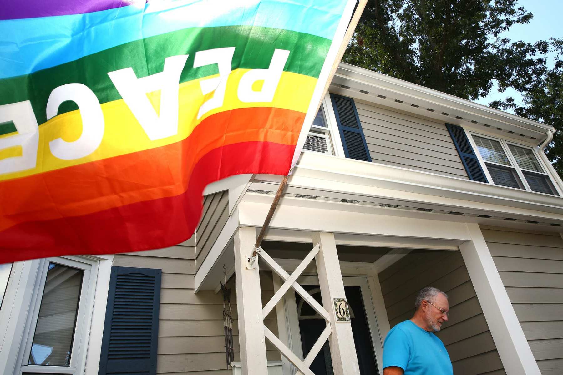 LGBTQ+ flag flying in front of a home.