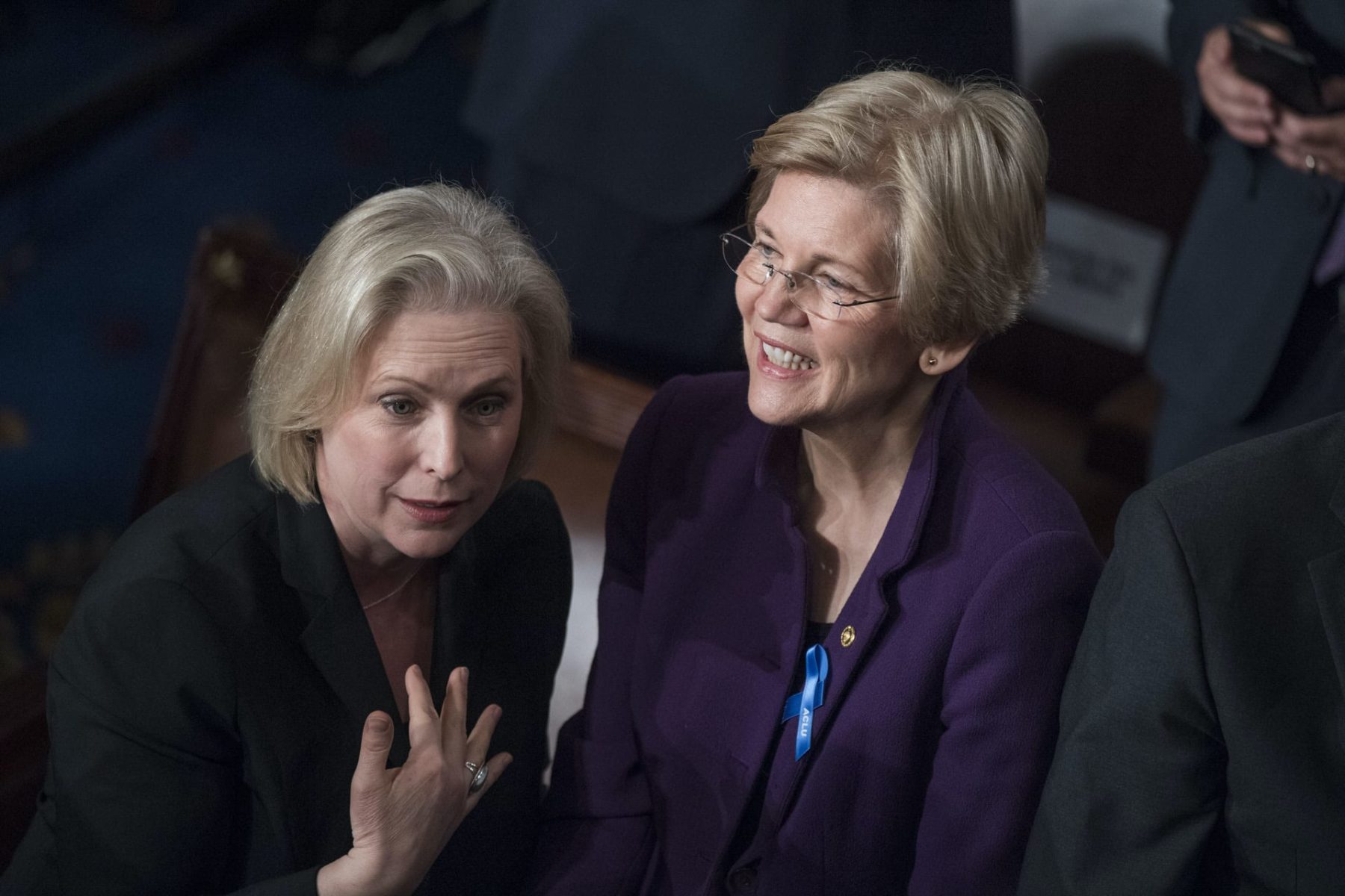 Sens. Kirsten Gillibrand and Elizabeth Warren talk to each other.