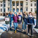 A group of trans youth walk in front of the South Dakota Capitol.