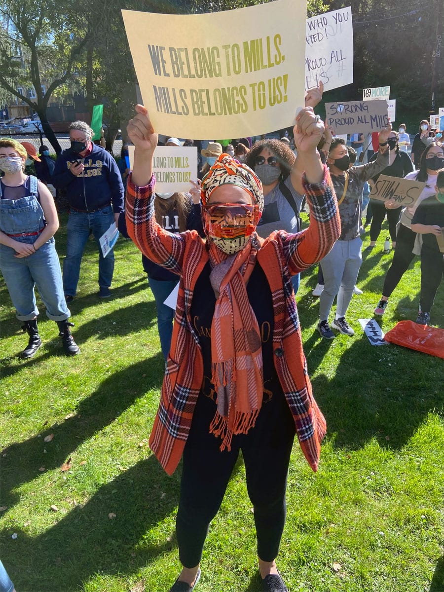 Renel Brooks-Moon holding a sign in support of Mills College.