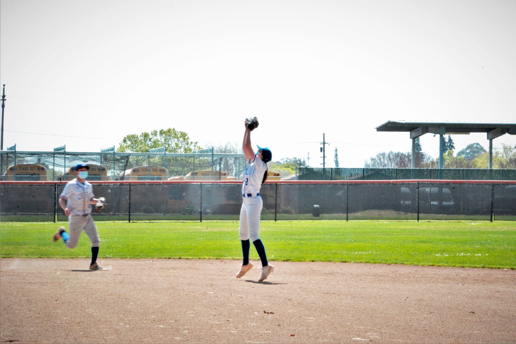 Maddie Etheridge catching a ball on the baseball field.