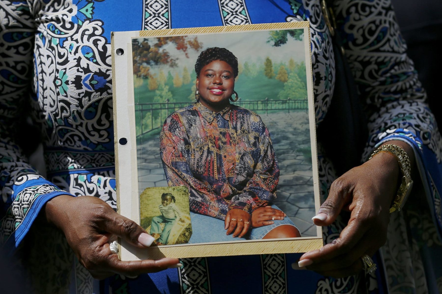 Antoinette Dorsey-James holds a picture of her sister Pamela Turner during a news conference.