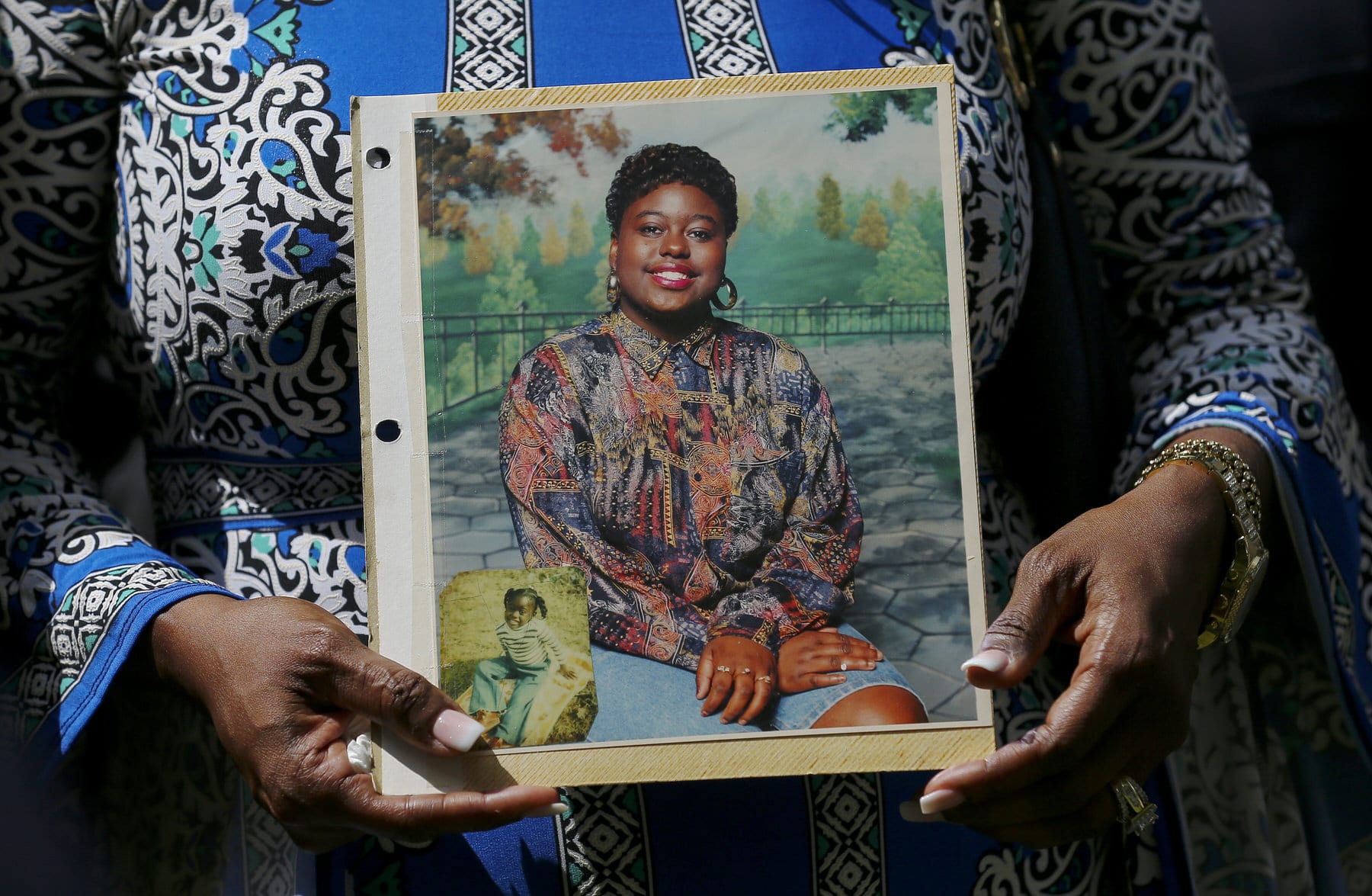 Antoinette Dorsey-James holds a picture of her sister Pamela Turner during a news conference.