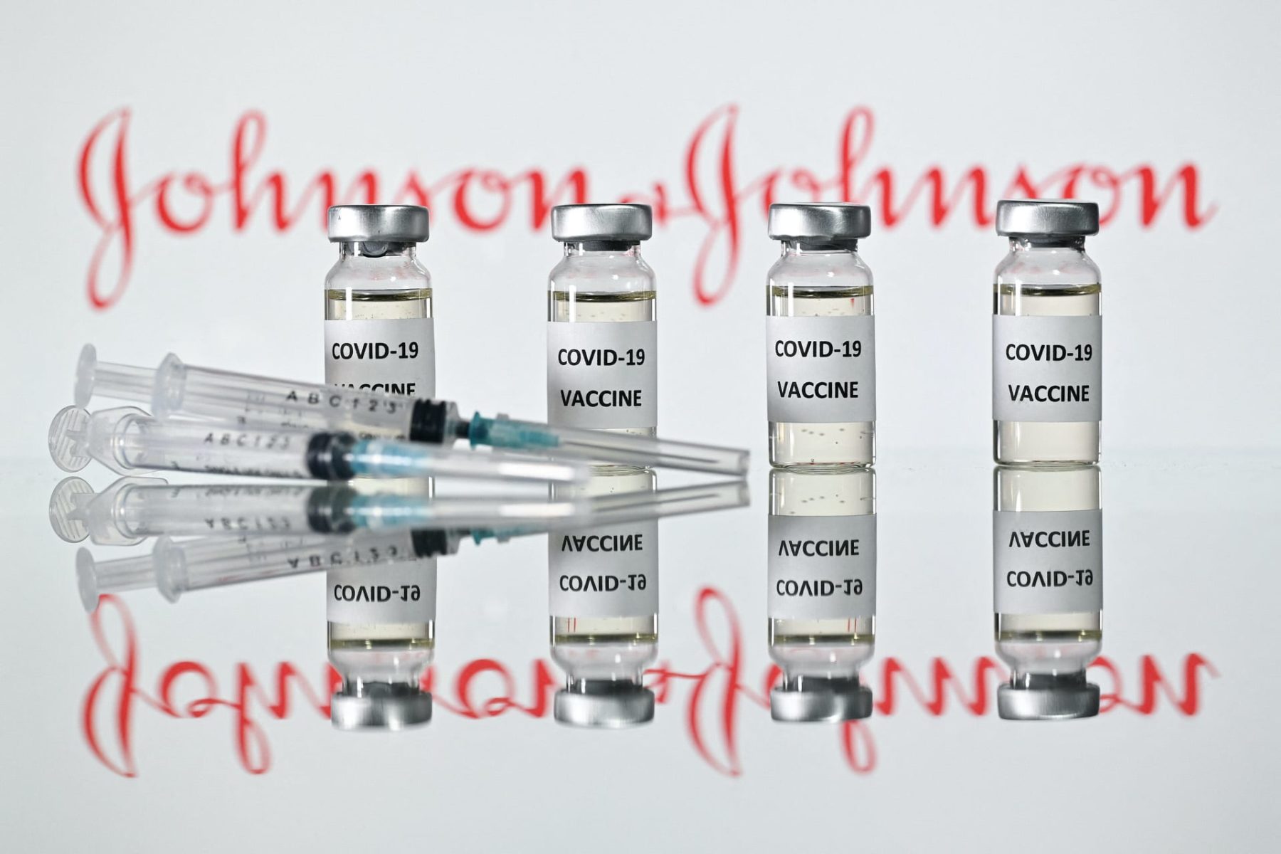 An illustration picture shows vials with Covid-19 Vaccine stickers attached and syringes with the Johnson & Johnson logo.