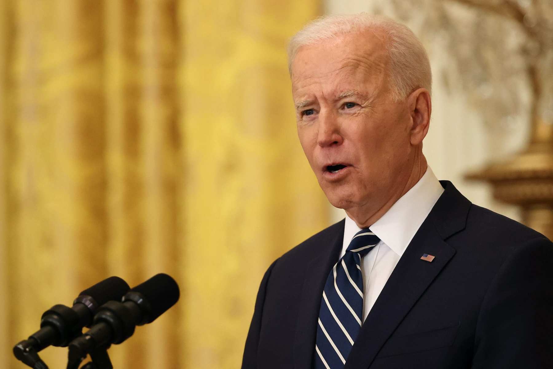 Joe Biden speaking at a dias into a microphone