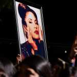 Fans hold up an image of Selena