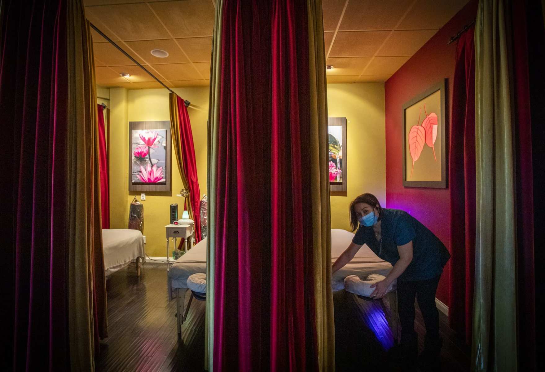 A woman makes a bed in a health spa.