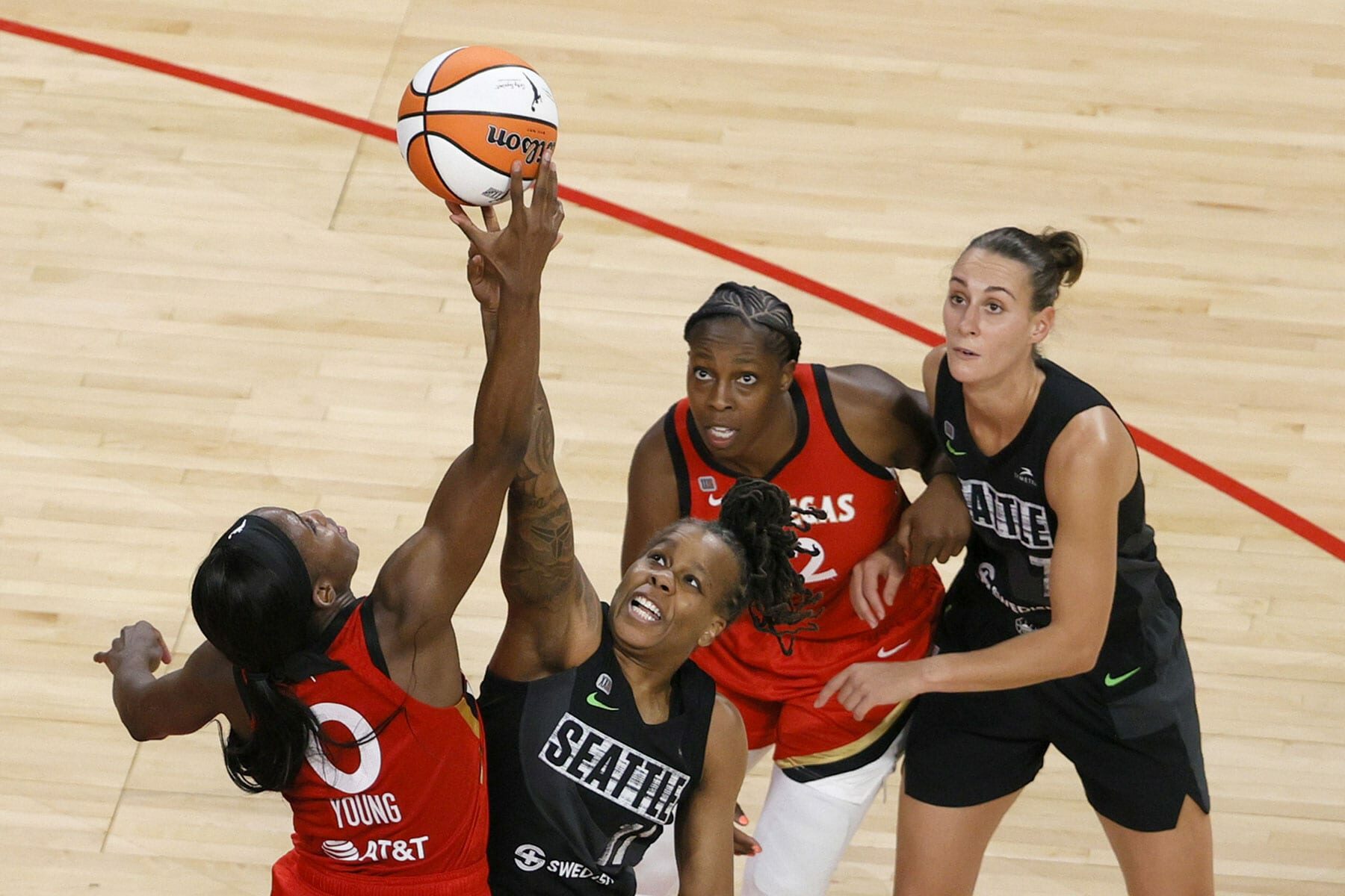 Jackie Young #0 of the Las Vegas Aces and Epiphanny Prince #11 of the Seattle Storm vie for a jump ball as Chelsea Gray #12 of the Aces and Stephanie Talbot #7 of the Storm look on during their game at Michelob ULTRA Arena on June 27, 2021