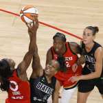 Jackie Young #0 of the Las Vegas Aces and Epiphanny Prince #11 of the Seattle Storm vie for a jump ball as Chelsea Gray #12 of the Aces and Stephanie Talbot #7 of the Storm look on during their game at Michelob ULTRA Arena on June 27, 2021