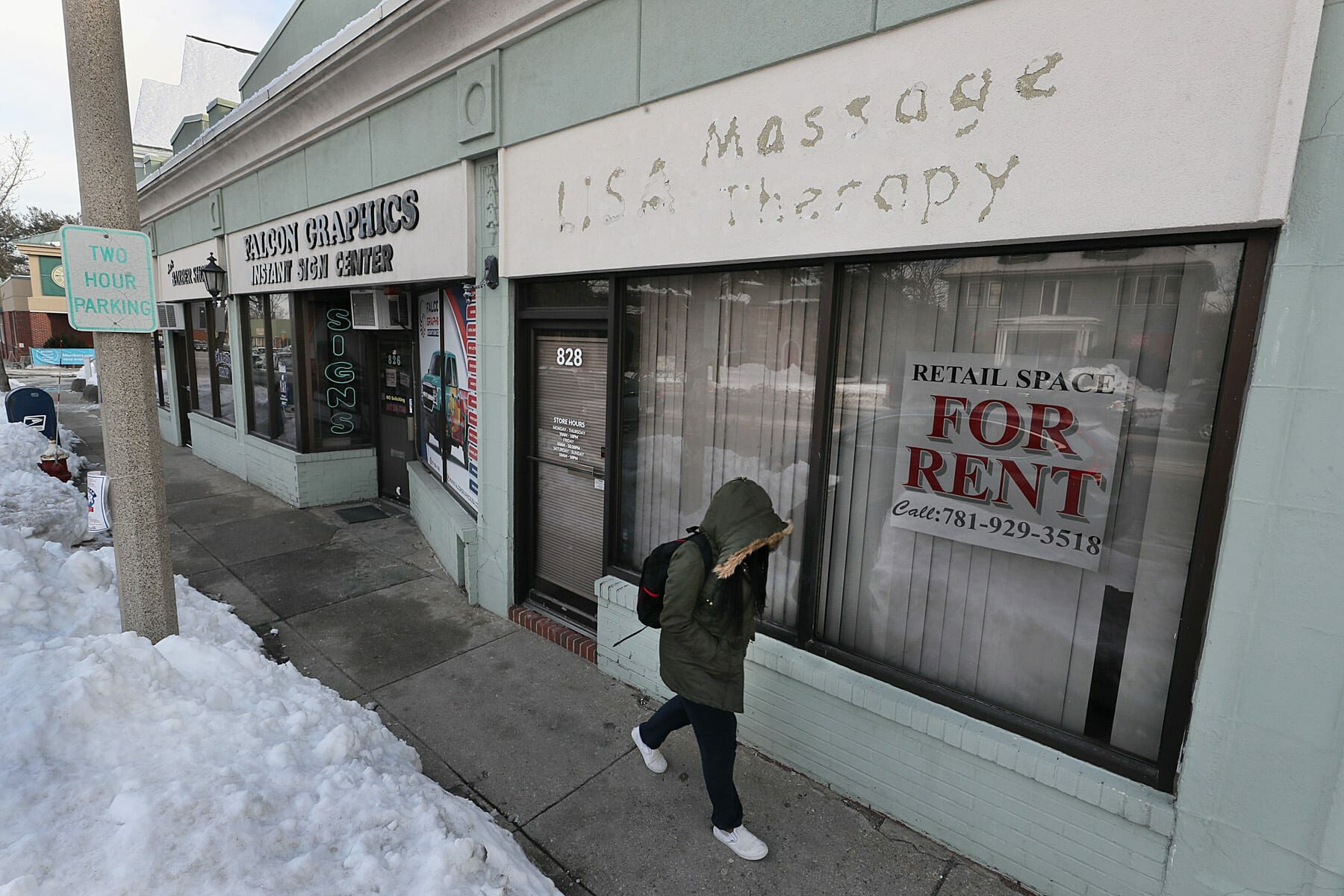A person walks by an empty massage parlor.