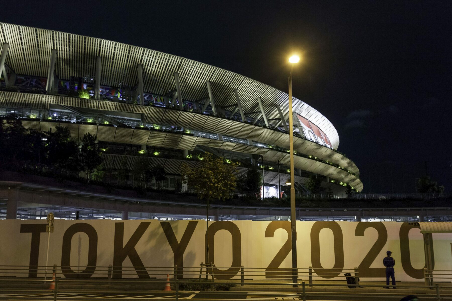 The outside of the Olympic Stadium in Tokyo at night.