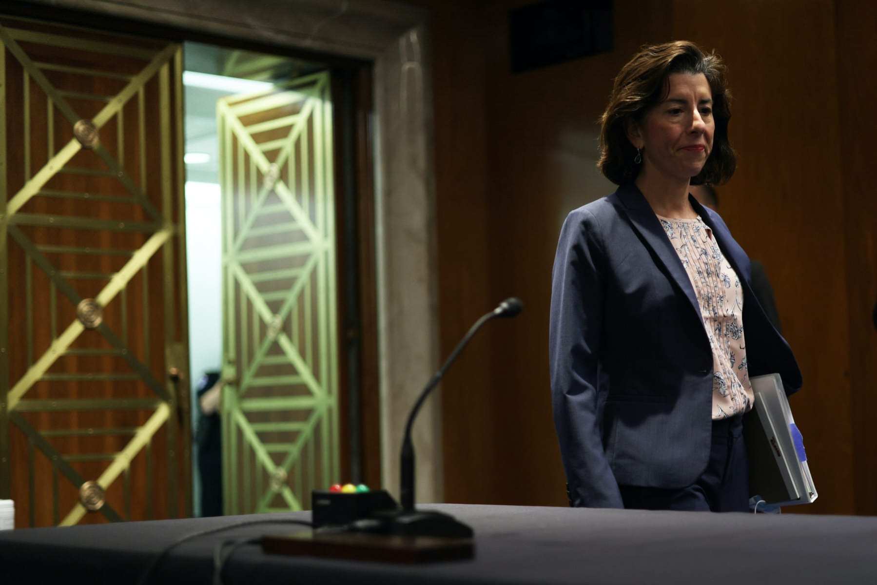 U.S. Secretary of Commerce Gina Raimondo walks into a hearing.