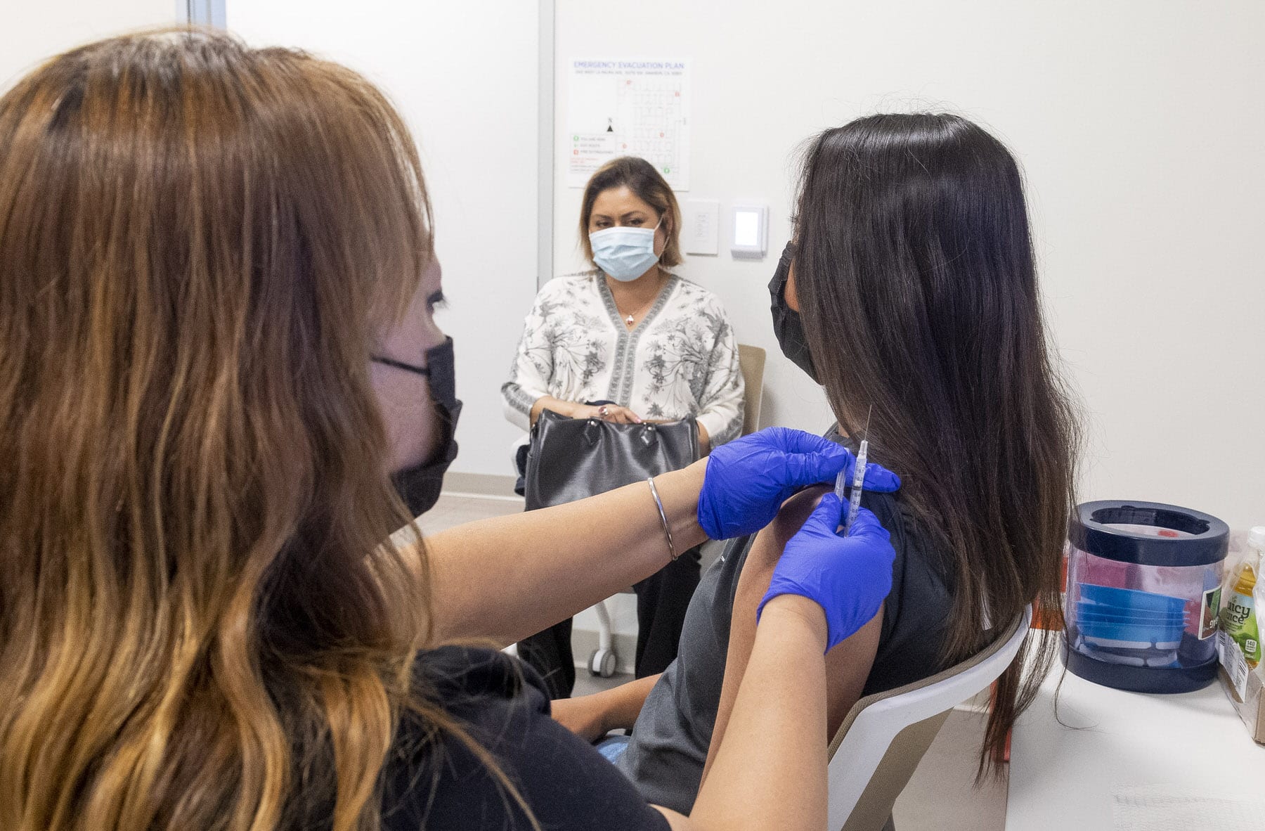 APRIL 28: A 16-year-old gets a Pfizer-BioNTech COVID-19 vaccine from Marie Thai, RN at UCI Health Family Health Center in Anaheim, CA on Wednesday, April 28, 2021 as her mom watches.