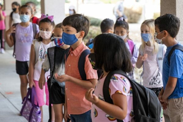 Second grade students stand with masks on.