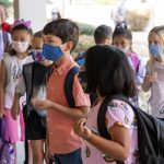 Second grade students stand with masks on.