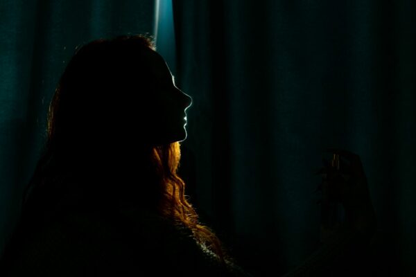 Silhouette of a young woman in the dark.