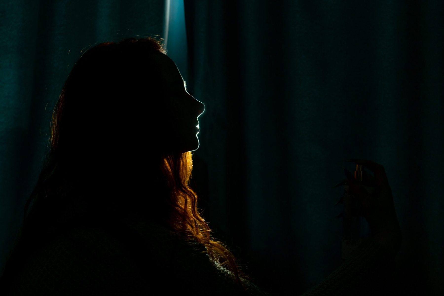 Silhouette of a young woman in the dark.