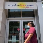 A woman walks past the the DC Department of Employment Services American Job Center.