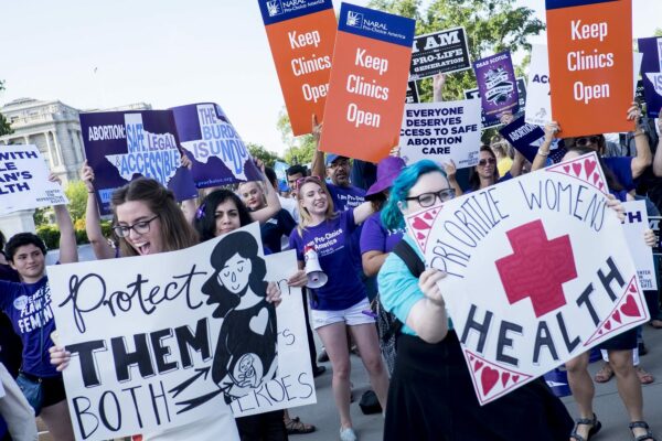 Activists hold signs both for and against abortion.