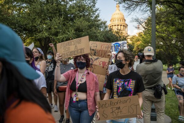 People holding signs that read 