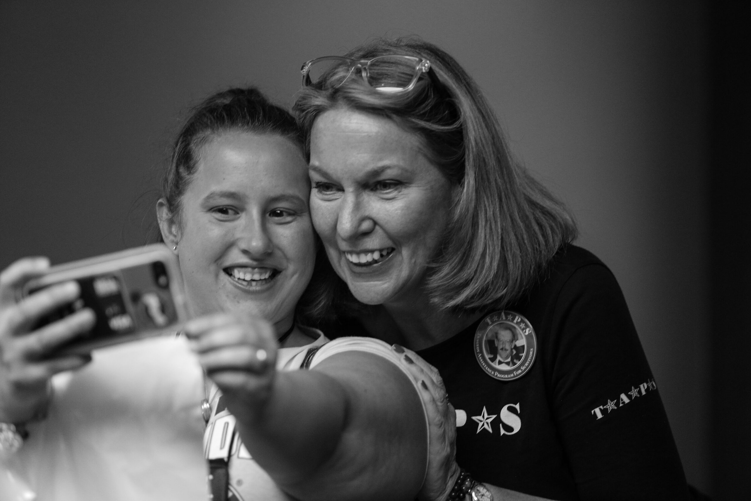 Bonnie Carroll smiles while taking a selfie with a young woman.