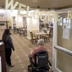 A woman enters the dining room of a nursing home
