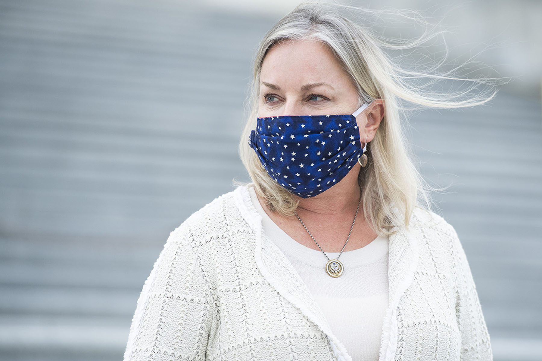 Susan Wild, wearing a blue face masks, stands on the steps on the U.S. Capitol.